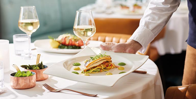 A seabass fillet served with vegetable linguini, pea puree and saffron butter sauce at Coast to Coast on-board Spirit of Discovery
